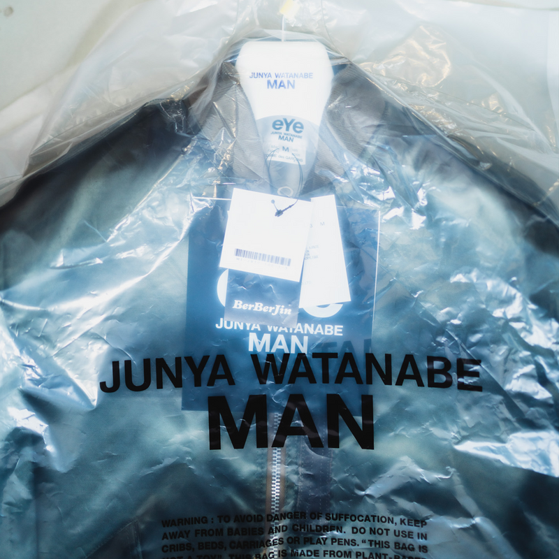 Junya Watanabe brand banner image of a jacket in a bag