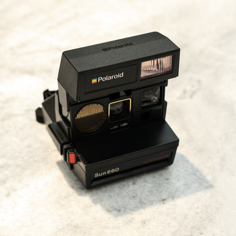 Polaroid - The iconic instant photo camera displayed on the floor