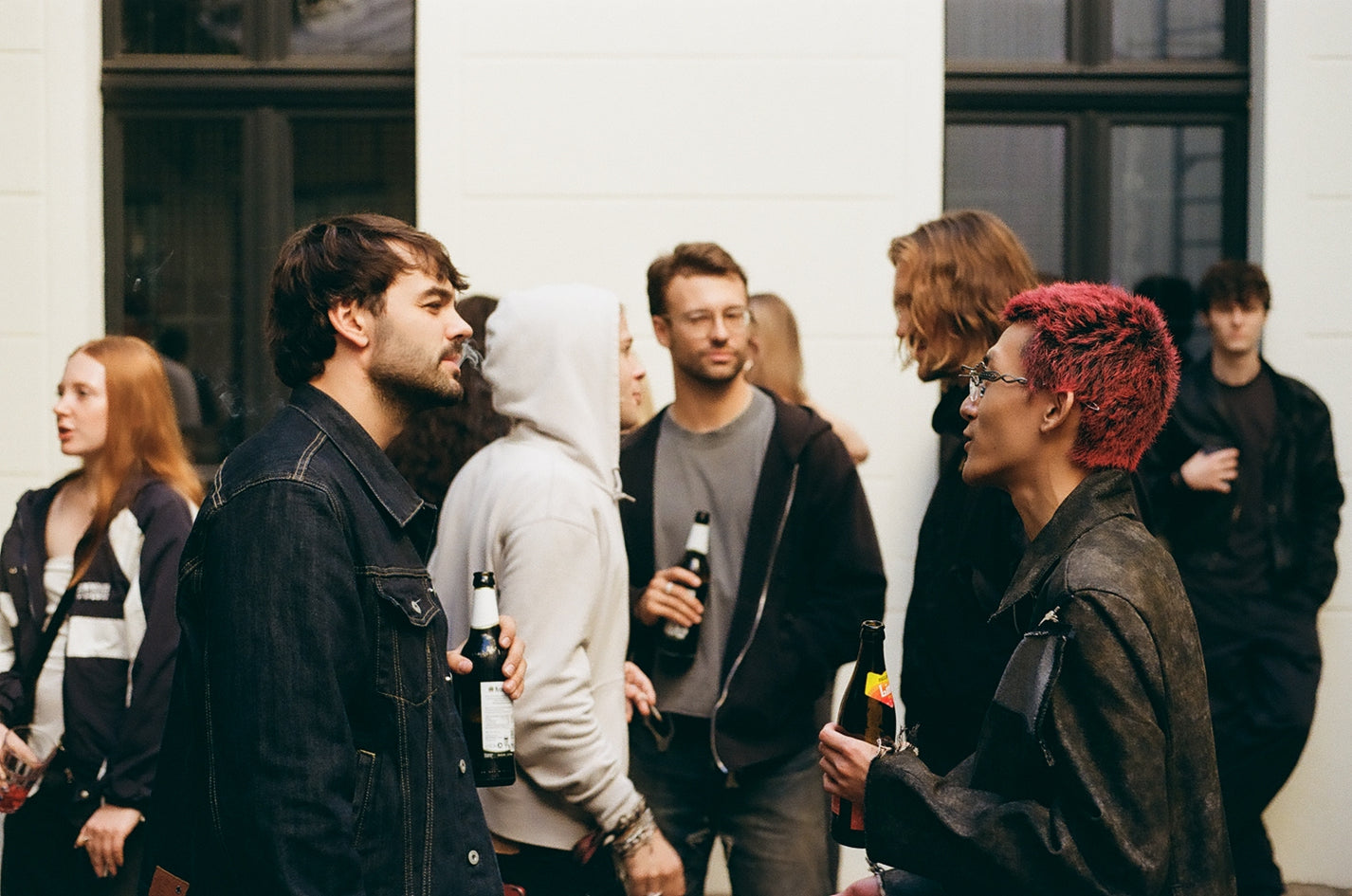 Puma x Non Faith Studios Event Recap. Group of people standing together, some holding bottles, against a white wall.