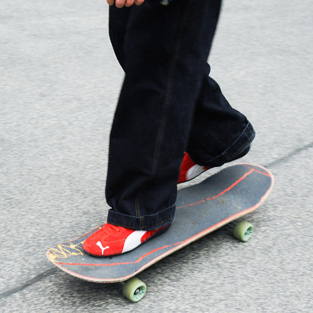 Red Puma Speedcat sneakers worn by someone on a skateboard