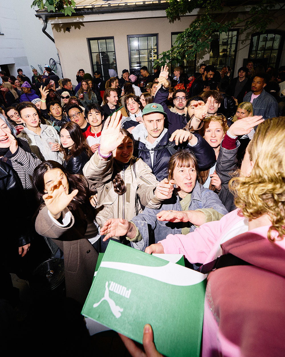 Crowd from Gate community in an event y Puma speedcat grabbing boxes