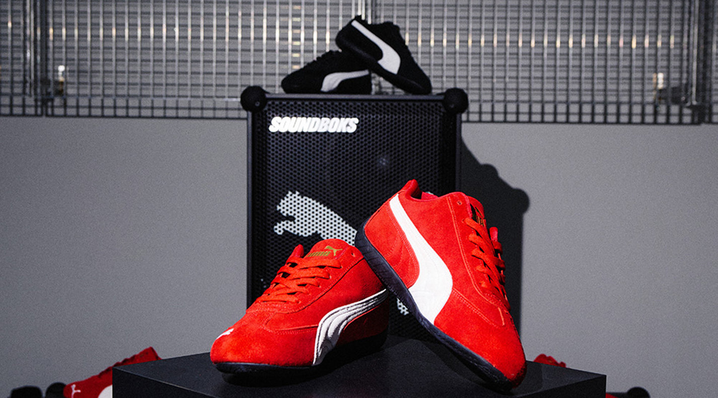 Red and black Puma Speedcat sneakers displayed inside the Gate store