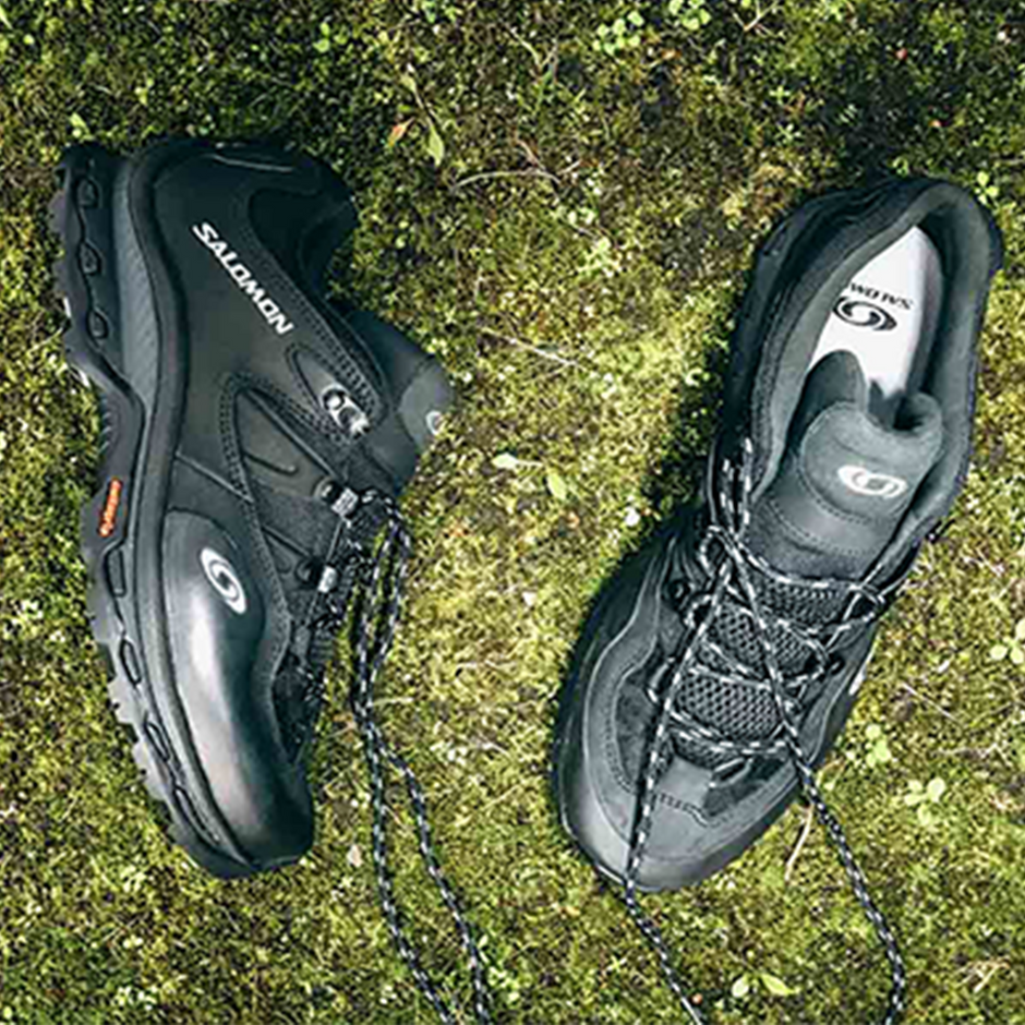 Salomon Banner image of fashionable outdoor sneakers with Gorpcore style laying on the grass