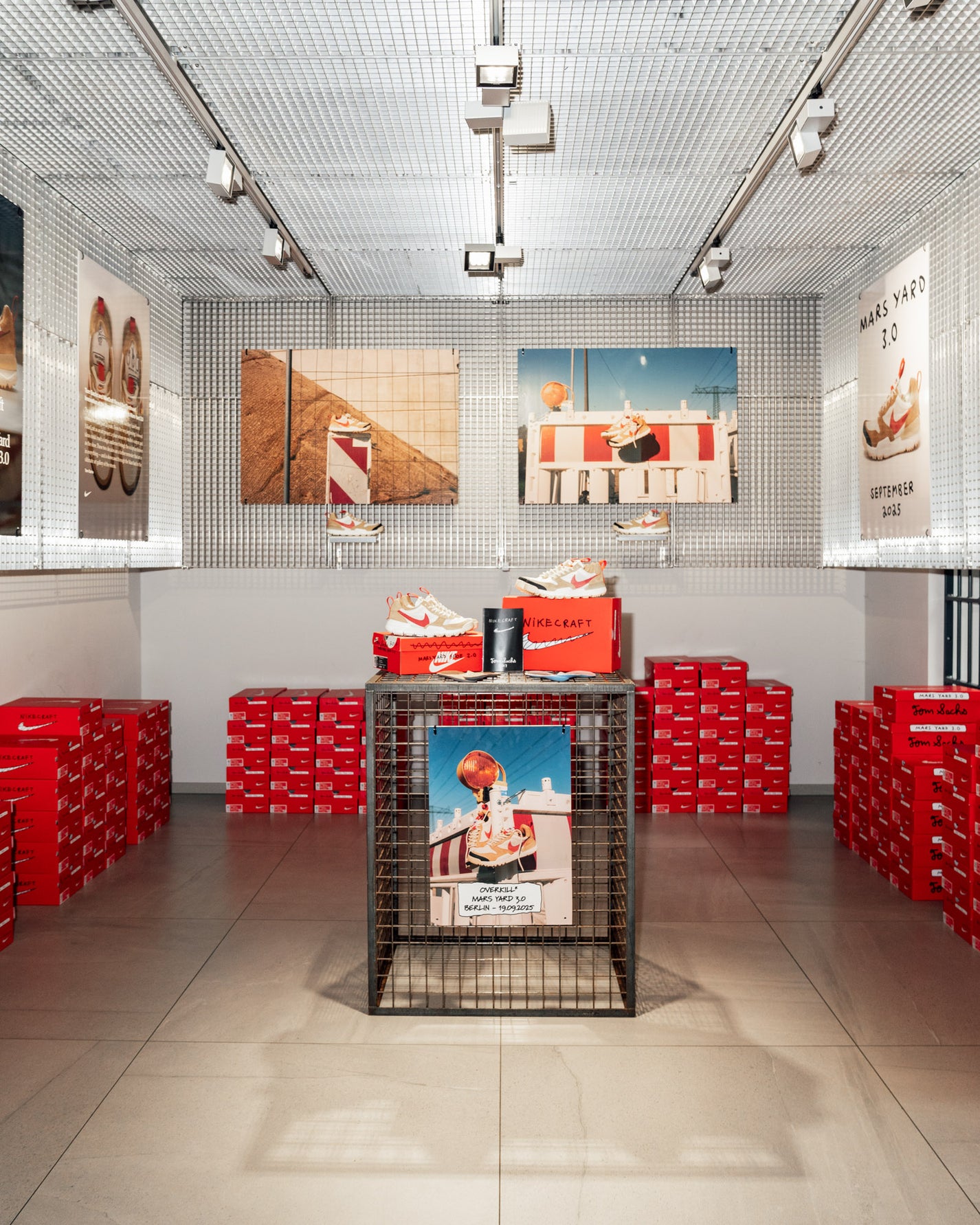 Storage room with red boxes and promotional posters on a tiled floor and white walls.RECAP: Tom Sachs x Nike Mars Yard 3.0
